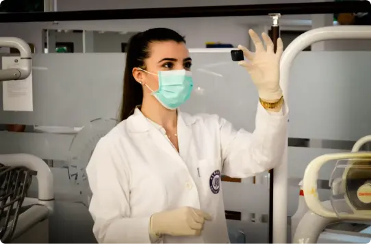 Woman inside laboratory examining specimen.
